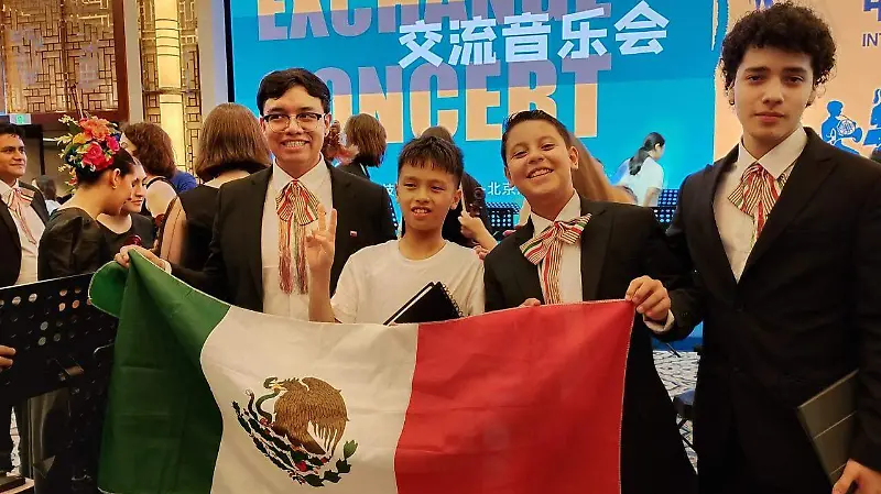 El director de esta camerata junto a alumnos integrantes de la agrupación.